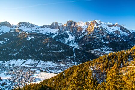 Dolomites mountain valley (Val di Fassa) with village Vigo di Fassa late evening light, seen from...