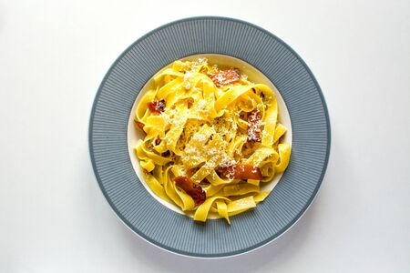 Tagliatelle fresh egg pasta with speck, olive oil and hard cheese (parmesan)の写真素材