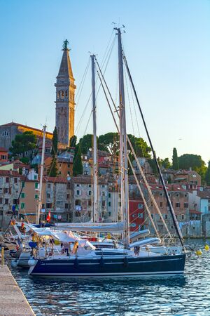 Rovinj town in Istria, Croatia, boat in port and baroque Church of St. Euphemia bell towerの写真素材