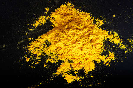 Yellow heap of curry powder on black background. Spice. Abstract background.の写真素材