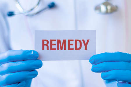 Remedy - text on card and doctor holding it. Healthcare or prevention concept.