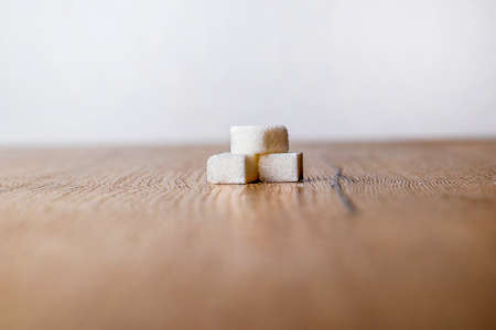 three pieces of sugar on a wooden board. sugar on wood table