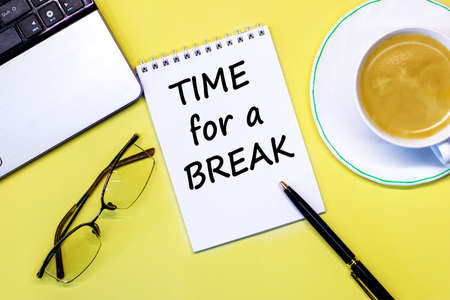 Office desk table with computer, pen, coffee cup and glasses. Time for a Break Text written on notebook page. Motivational Concept imageの写真素材