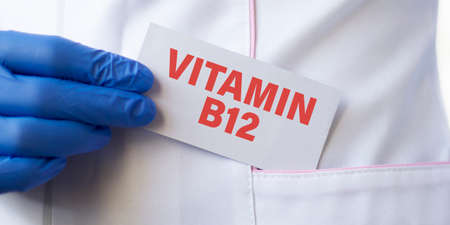 Doctor holding a card with Vitamin B12, Medical concept