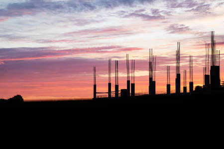 Silhouette of building structures on the background of sunset orange, violet and pink color, real estate construction, work architecture business conceptの写真素材