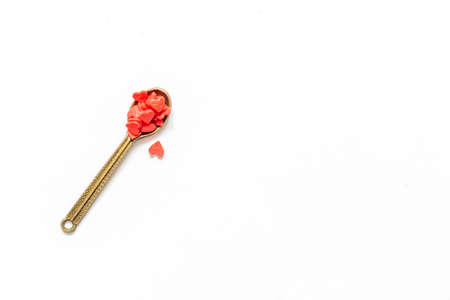 Red little hearts on metalic spoon on white background. Happy Valentine's day concept. Medicine and health maintenance concept.の写真素材