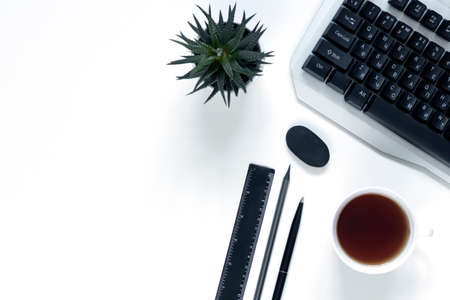 On a light background are a pen, computer, flower, cup of coffee. Place to insert text. Close up top...