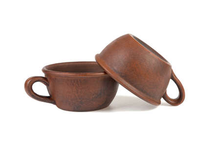 two clay cups one on another isolated on white backgroundの写真素材