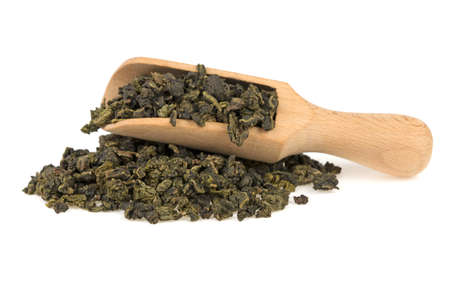 green tea on a wooden spoon on a white background