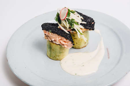 dish with grilled fish over zucchini and souce