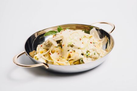 pasta in a metal vessel on whiteの写真素材