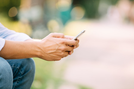 Close up of a man using mobile smart phone outsideの写真素材