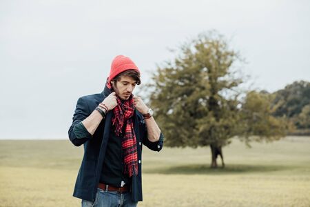 cool young man on a country road with field and treesの写真素材