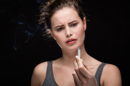 close up of a hand with cigarette, smoking concept on black backgroundの写真素材