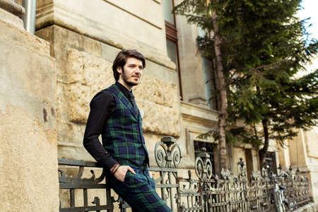 elegant man standing outside, wearing green plaid costume