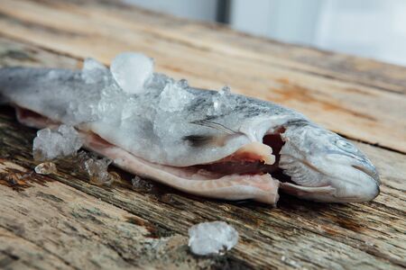 fresh fish with ice on a wooden table