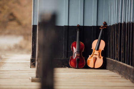 violins resting on an old wooden porchの写真素材