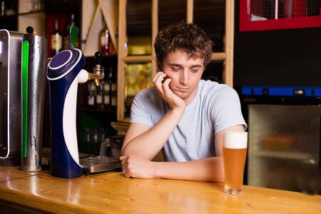 young bartender serving beer in a pubの写真素材