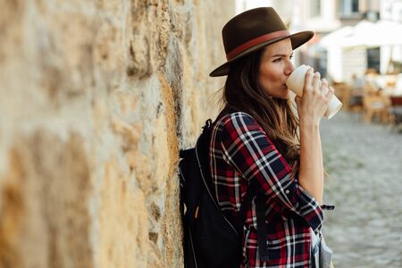 young woman, traveler, with a map and a backpack on streets of old citadel, exploringの写真素材