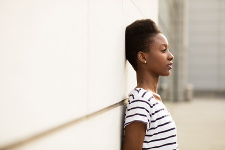 smiling young black woman in striped shirt standing outsideの写真素材