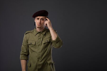young military with red beret and green uniform on gray backgroundの写真素材