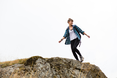 young beautiful woman traveling on mountains with backpack on her backの写真素材