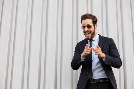happy and expresive elegant gentleman pointing the camera with big smileの写真素材