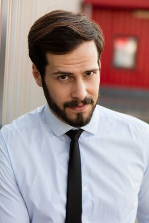 portrait of a office man with blue shirt and tie outside looking at cameraの写真素材