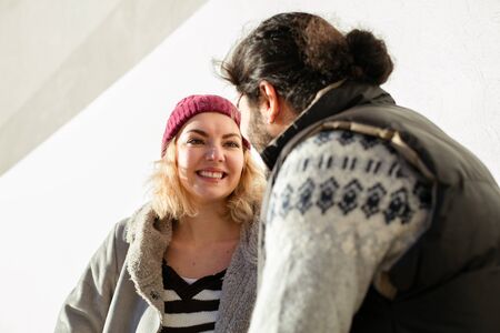 nice joyful couple standing outside on a bench and exchanging giftsの写真素材