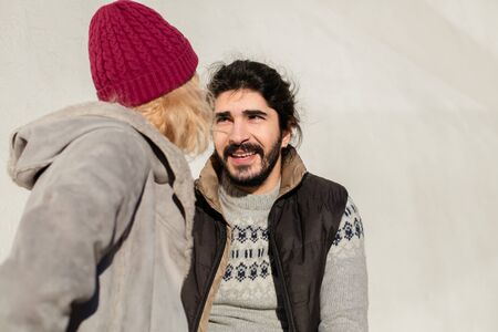 nice joyful couple standing outside on a bench and exchanging giftsの写真素材