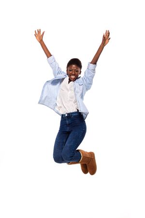 afro amerian woman jumping and smiling on white backgroundの写真素材