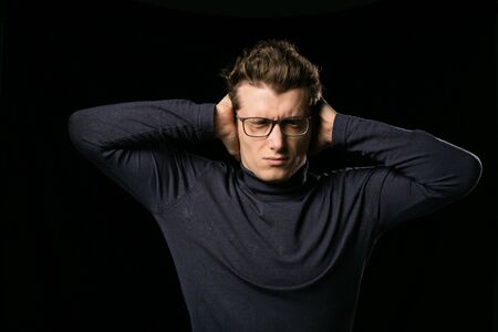 smart man with elegant glasses covering his ears to stop hearing sound