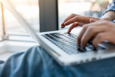 close up of hands typing on a laptop keyboardの写真素材
