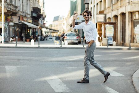 elegant man with sunglasses crossing the streetの写真素材