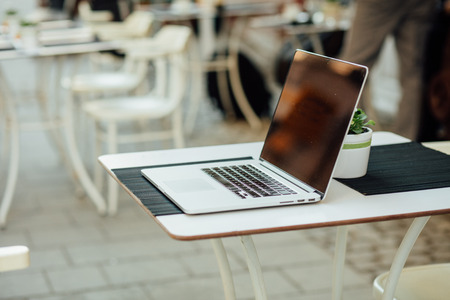 gray open laptop on terrace table outside in urban areaの写真素材