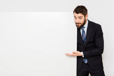 elegant man presenting a white panel from his right sideの写真素材