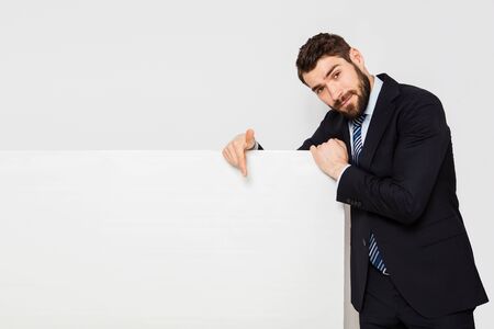elegant man presenting a white panel from his right sideの写真素材