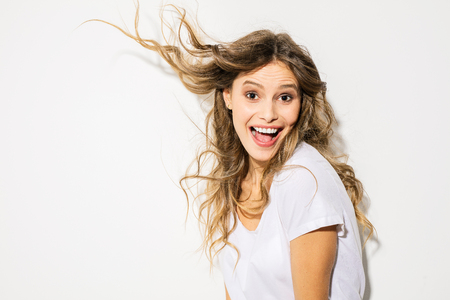 portrait of young and beautiful woman, expressive face, in white shirt smiling to cameraの写真素材
