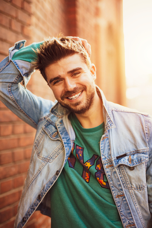 smiling and happy cool man, looking to camera and having a good day, lifestyle picture with a modern guy on the streetの写真素材