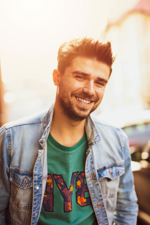 smiling and happy cool man, looking to camera and having a good day, lifestyle picture with a modern guy on the streetの写真素材