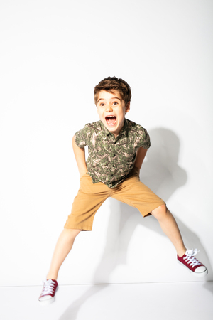 little boy jumping and smiling on white backgroundの写真素材