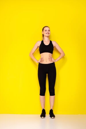 proud young woman for her sport result on her body. athletic woman in sportwear with positive attitude looking to cameraの写真素材