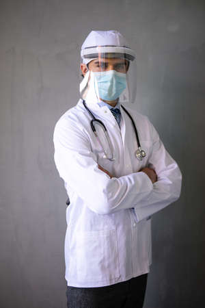 professional doctor with double virus protection on face and mouth with stethoscope on grey backgroundの写真素材
