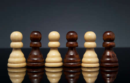 White and black pawns, on dark gray background  Landscape format の写真素材