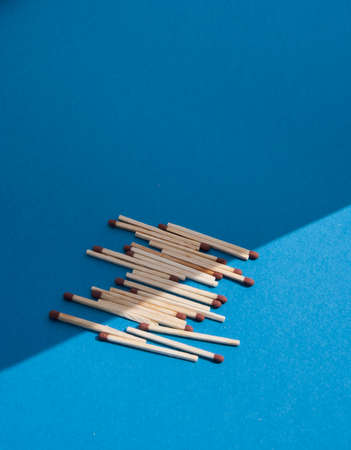 Matches on light blue background. Half light, half shadow. 50/50.の写真素材