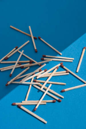 Matches on light blue background. Half light, half shadow. 50/50.の写真素材