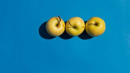 Fresh Yellow Apples on light blue background. の写真素材