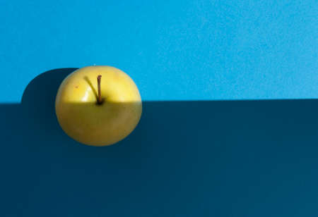 Fresh Yellow Apple on light blue background. の写真素材