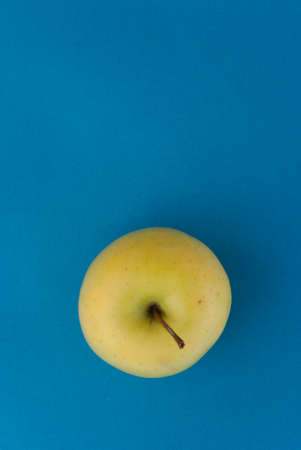 Fresh Yellow Apple on light blue background. の写真素材