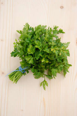 Bunch of ripe parsley on wood textured background. Above view.の写真素材